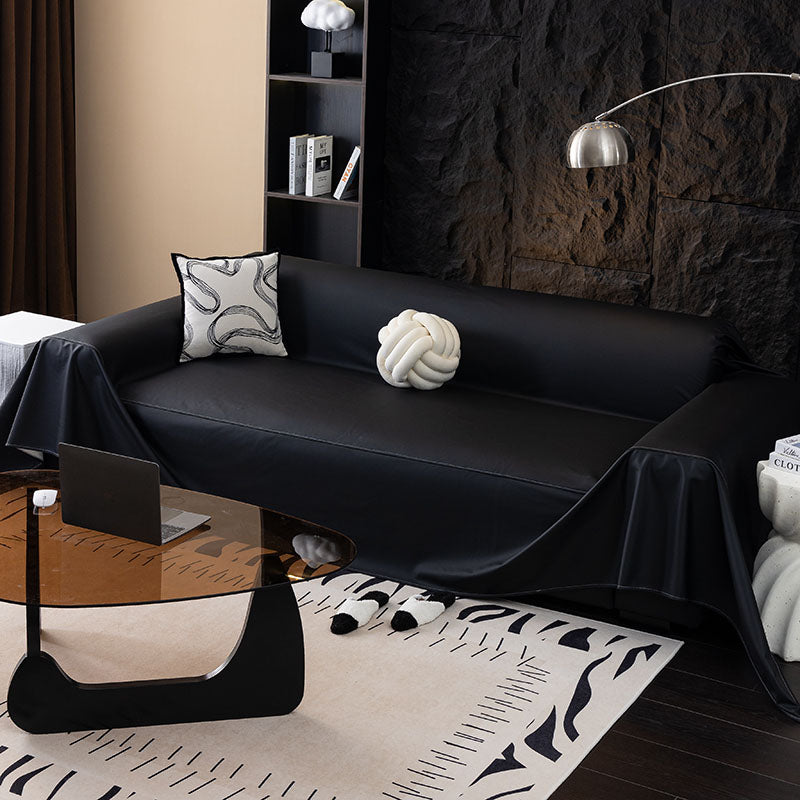 Faux leather sofa throw, Onyx black, draped over a sofa