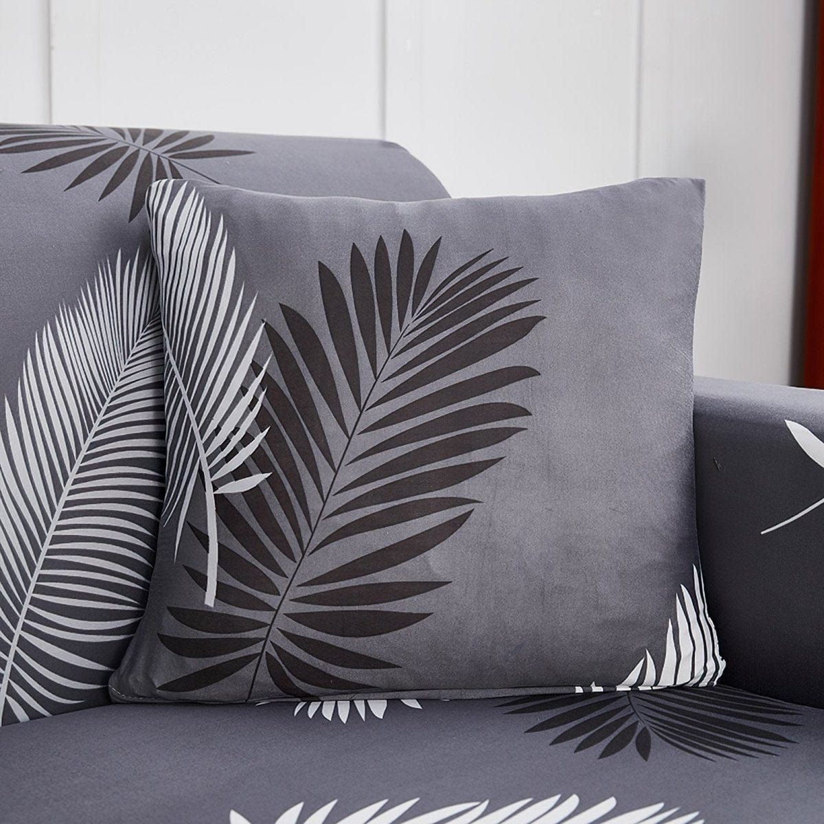 Stretch cushion cover 45 × 45 cm (18 in), single, Grey palm leaves, fitted on a sofa